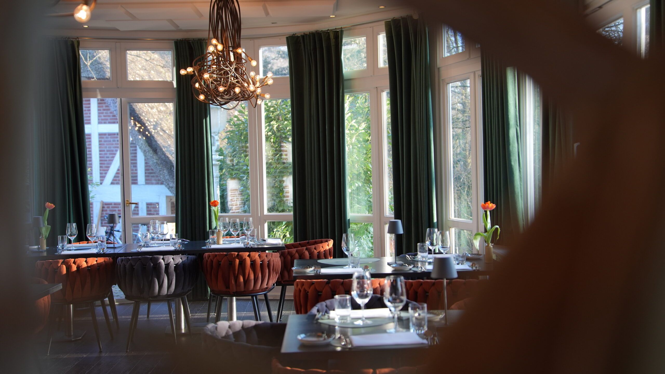 Gastraum des Pfeiffers mit Kronleuchter und Blick in den Garten