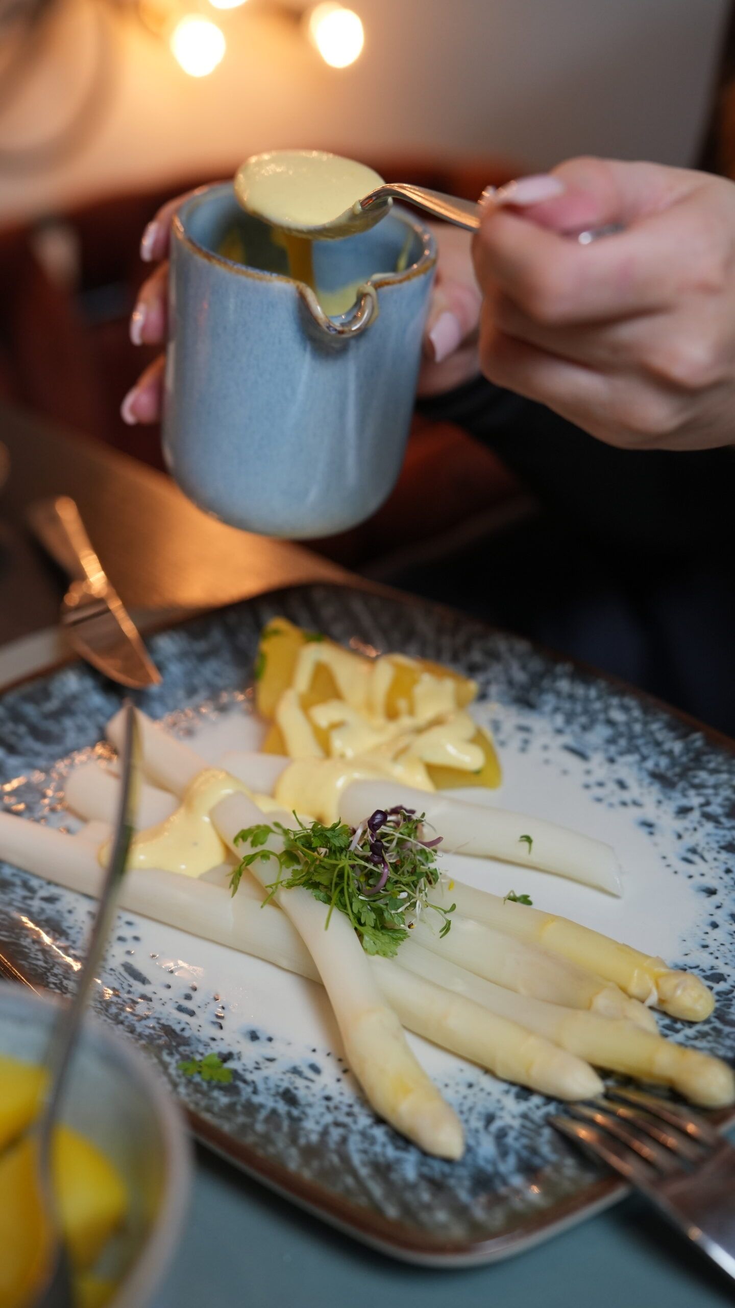 Weißer Spargel mit Kräutern auf blauem Teller